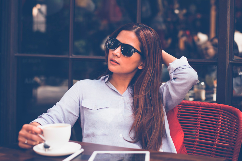 chica tomando un cafe con sus gafas de sol puestas