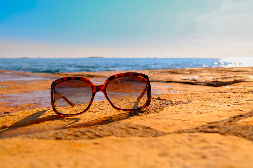 gafas de sol sobre piedras en la playa